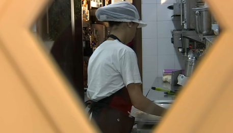 Mujer trabajando en cocina de bar