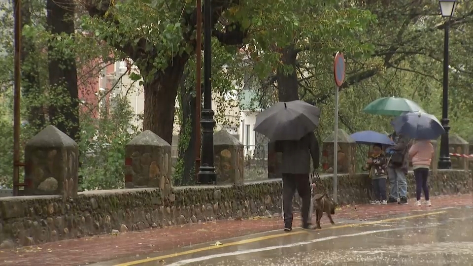 Personas paseando con paraguas durante la borrasca Claudia