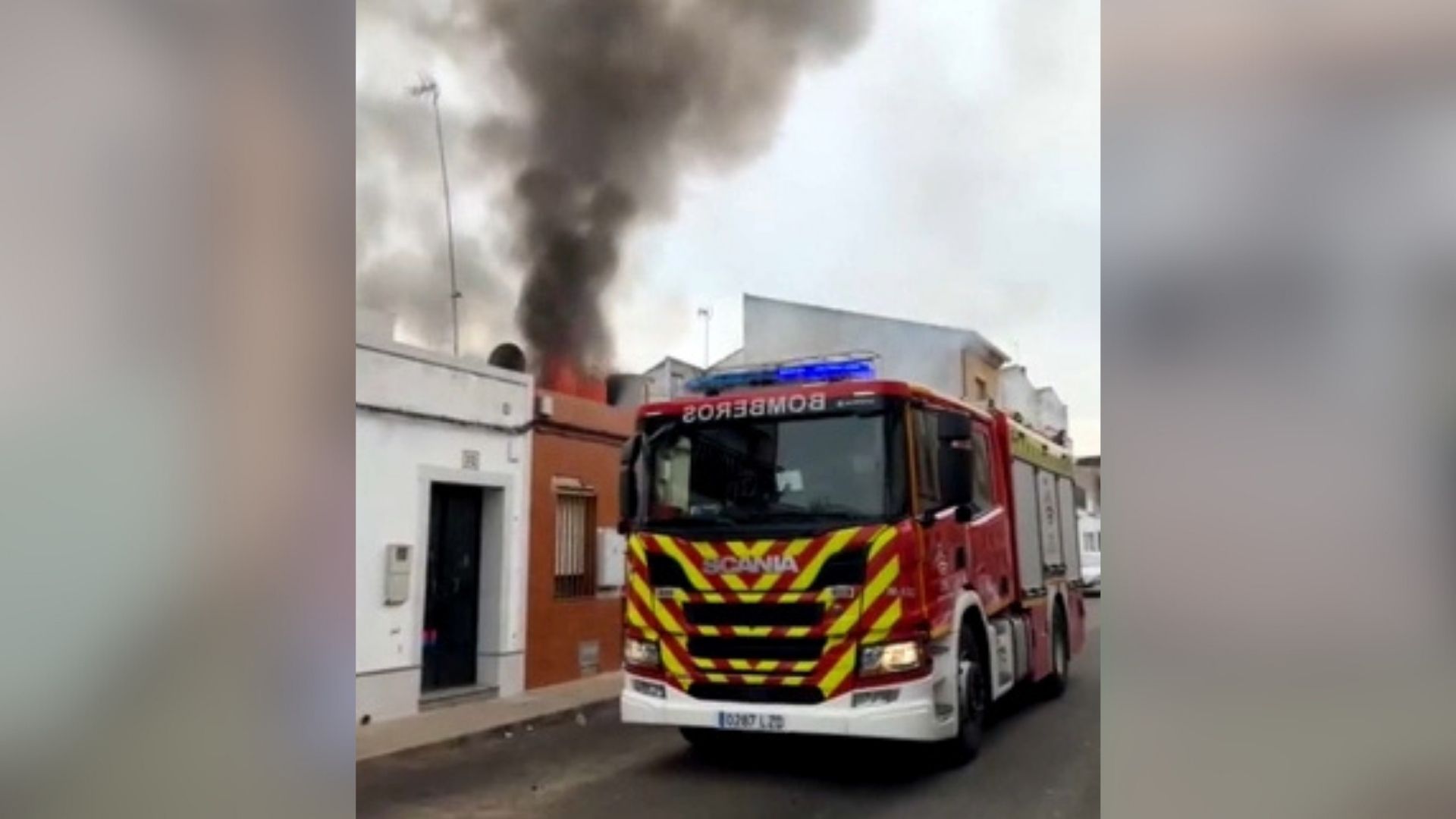 Vivienda incendiada en Montijo junto a un camión de los bomberos que trabaja en su extinción