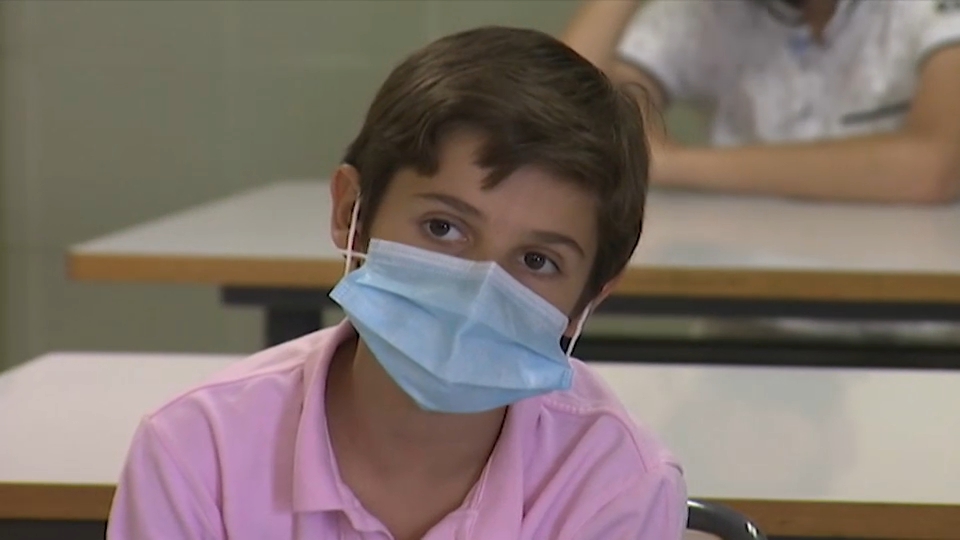 Joven utilizando mascarilla en el interior de un aula - Imagen de archivo