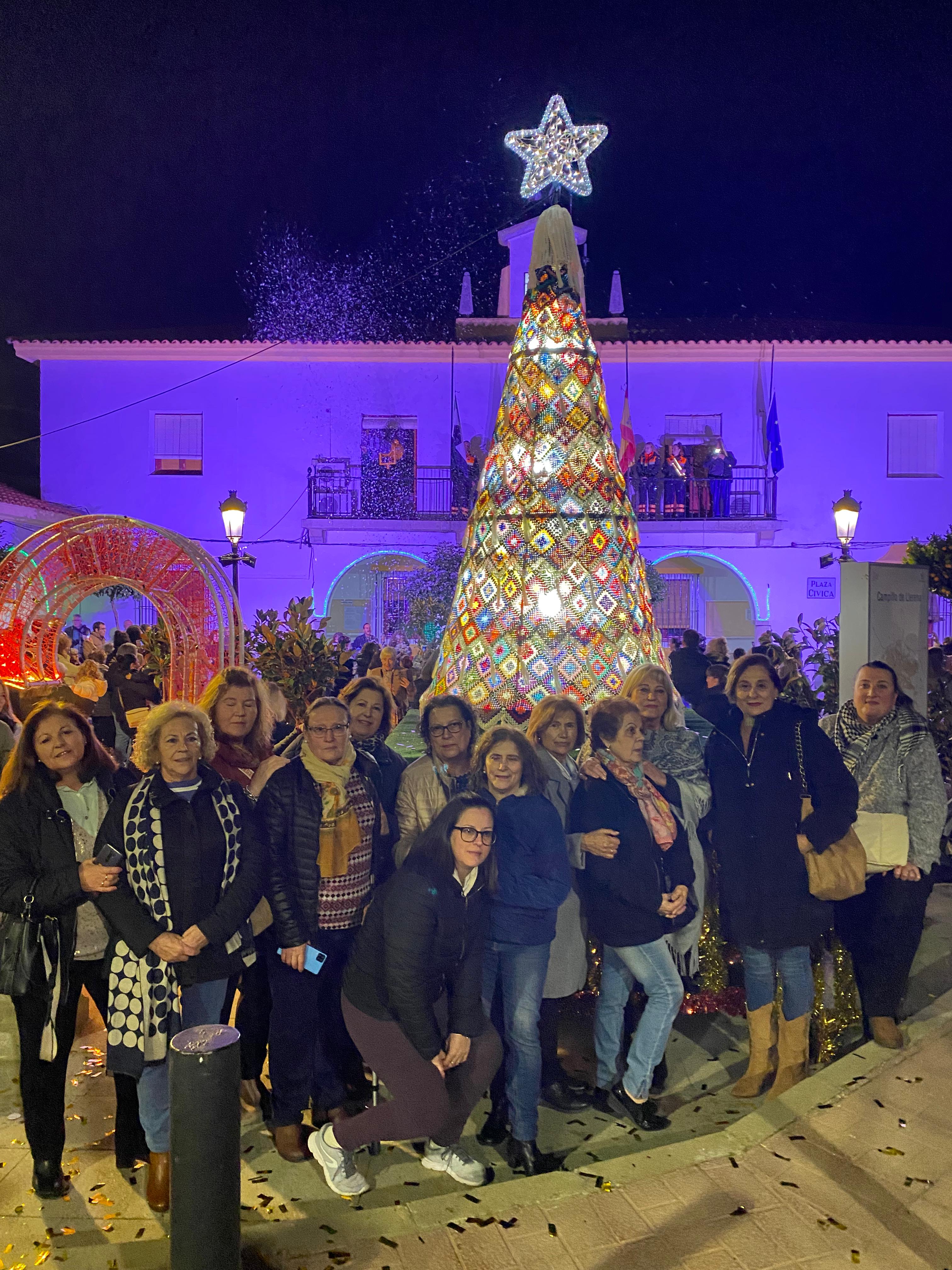 Las mujeres de la asociación 'El dedal' posando junto a su árbol de ganchillo