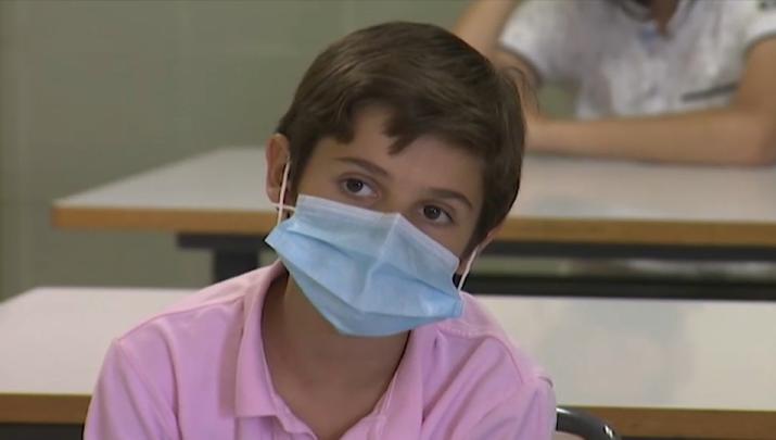 Joven utilizando mascarilla en el interior de un aula - Imagen de archivo