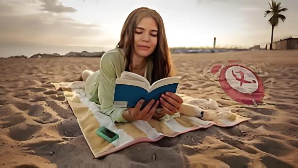 Joven leyendo en la playa