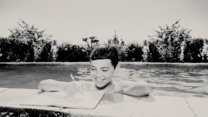 Niño haciendo deberes en una piscina