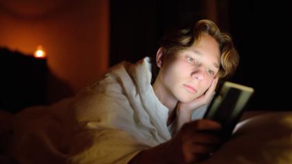 adolescente chateando con el móvil por la noche