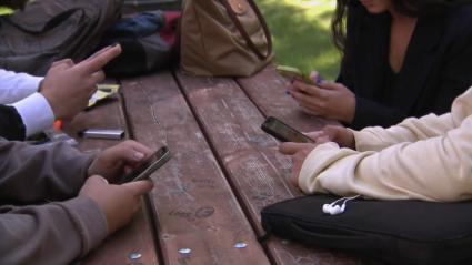 Jóvenes utilizando teléfonos móviles - Imagen de archivo.