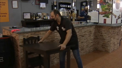 Un trabajador prepara su bar para las nuevas restricciones