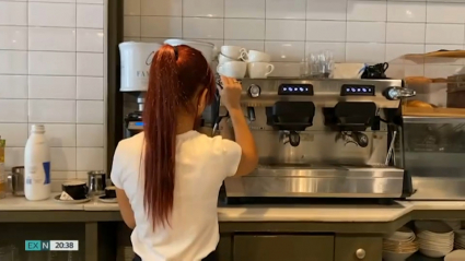 Camarera preparando un café en una cafetería