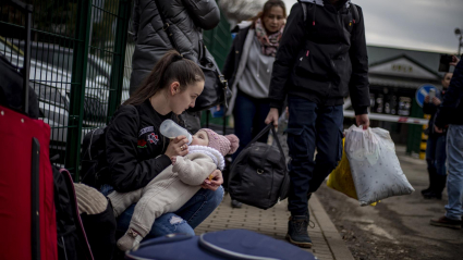 Una mujer alimenta a un niño mientras las personas que huyen de Ucrania llegan a Eslovaquia a través del cruce fronterizo de Ubla, el 25 de febrero de 2022. Eslovaquia dijo que permitirá que los ucranianos que huyen entren al país tras el paso de Rusia Operación militar en Ucrania.