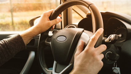 manos de hombre al volante en el coche