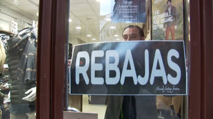 Colocando el cartel de rebajas en una tienda de Plasencia.