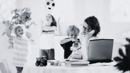 mujer trabajando a la vez que cuida a sus hijos