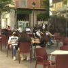 Clientes consumiendo en la terraza de un bar.