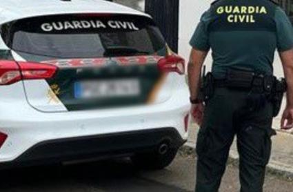 Efectivo de la Guardia Civil junto a un vehículo