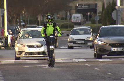 Persona cirulando con un patinete eléctrico por la ciudad