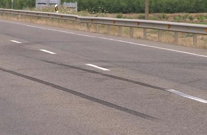 Marca de las ruedas de un vehículo en una carretera - Imagen de archivo