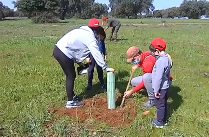 Familia plantando un alcornoque en el Parque Natural de Cornalvo  (Badajoz)