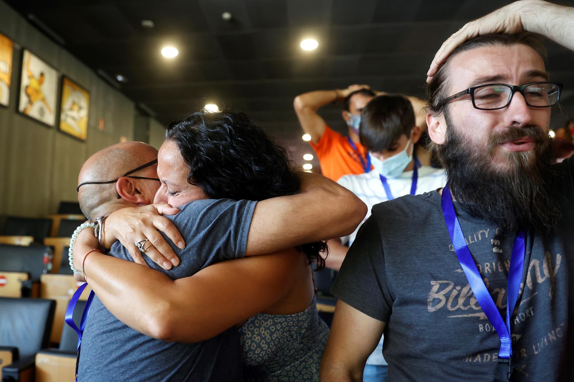 Los padres del escalador español Alberto Ginés se abrazan mientras celebran la medalla de oro de su hijo en escalada mientras sigue su actuación por televisión, este jueves en Madrid.