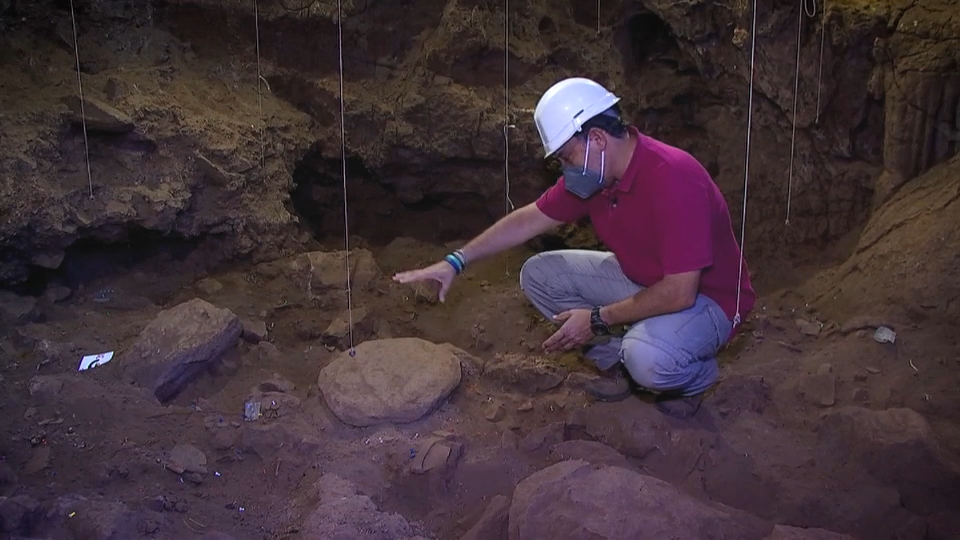 Hipólito Collado, jefe de Sección de Arqueología de la Junta, señala los restos del ritual en la cueva de Los Caballos