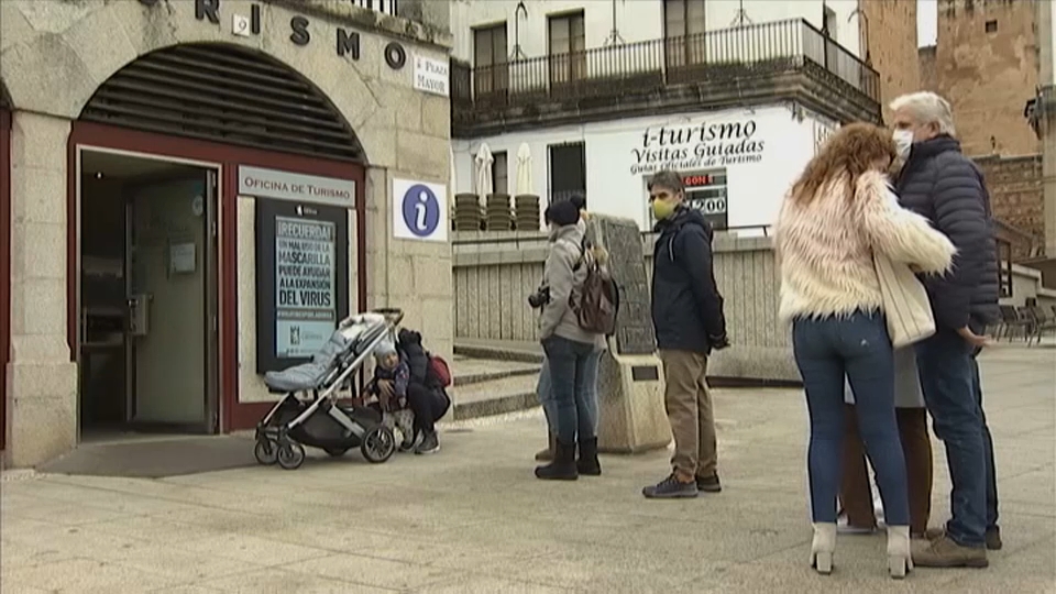 Turistas haciendo cola para ser atendidos en la oficina de turismo de Cáceres