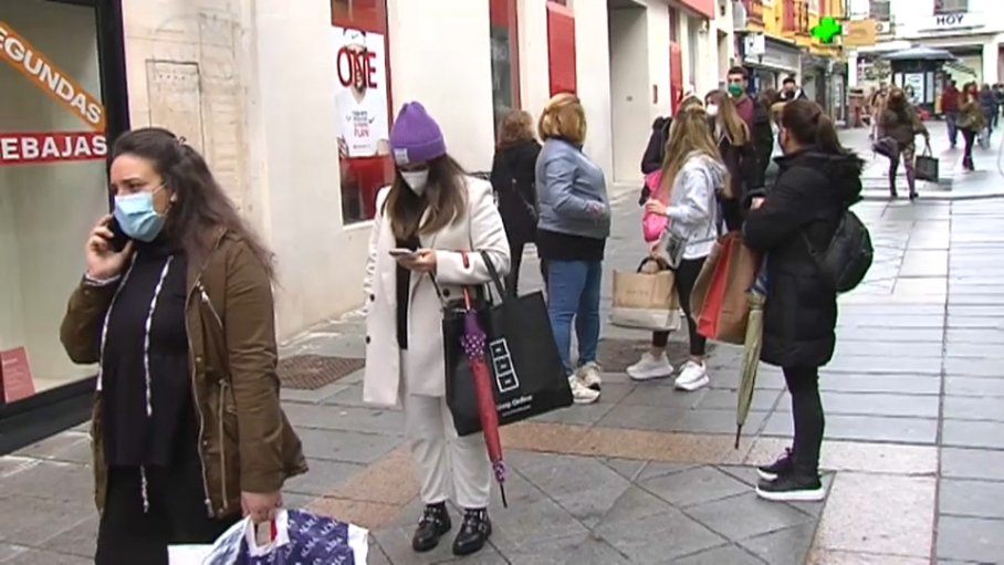 Clientes esperando para entrar en las tiendas esta mañana en la Calle Santa Eulalia de Mérida.