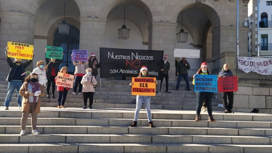 Comerciantes cacereños en la escalinata del Ayuntamiento, manifestándose en contra del Mercado Navideño en la Plaza Mayor