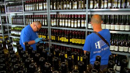 Usuarios del taller de reciclaje de Placeat colocan botellas de vino usadas para su posterior reutilización