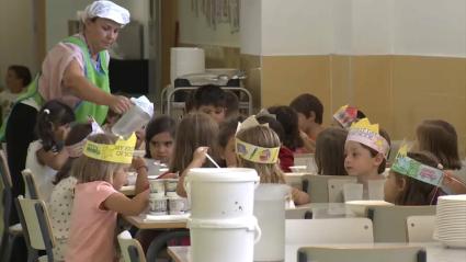 Una persona sirve agua en un comedor escolar