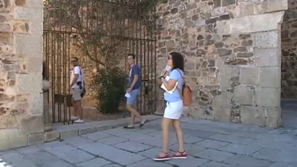 Una turista se acerca a la puerta de acceso a la Torre de Bujaco de Cáceres