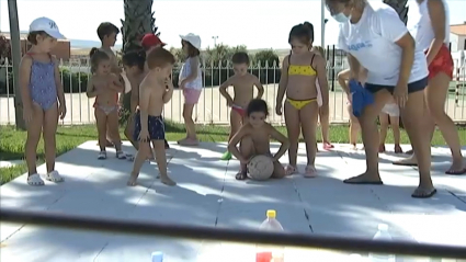Niños pequeños jugando a los bolos en bañador