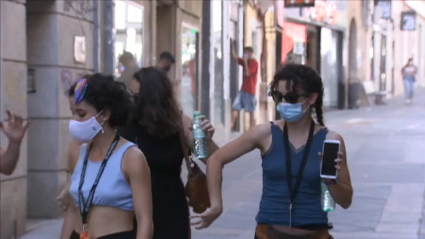 Jóvenes usando las mascarillas en la calle.