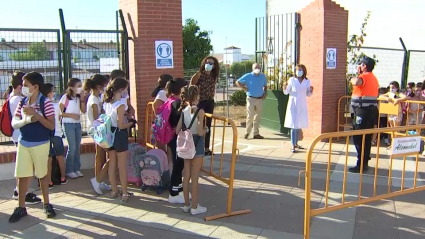 En el colegio Virgen de la Luz de Alconchel, la directora ha dado la bienvenida a padres, madres y alumnos. Escolares esperando para entrar al colegio entre vallas y de forma ordenada.