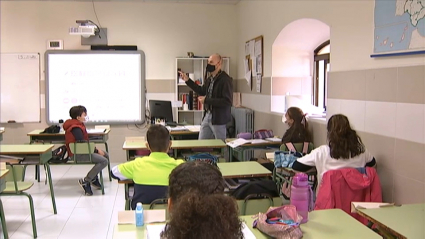 Un profesor, con mascarilla, da clase a sus alumnos