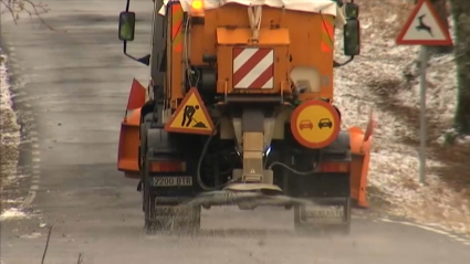 Máquina esparciendo sal contra el hielo en la carretera