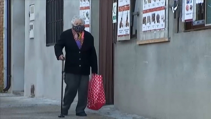 Anciano paseando en un pueblo con mascarilla