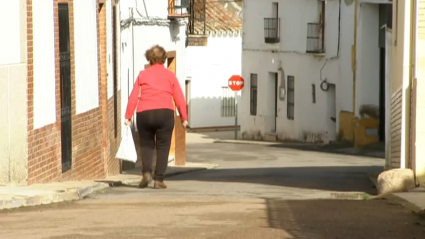 Mujer con bolsa de la compra por la calle de un pueblo