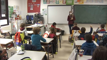 Alumnos de Primaria del colegio Castra Caecilia de Cáceres en su regreso hoy a las aulas. Imagen del interior de un aula con alumnos en sus pupitres y su profesora al pie de la pizarra.