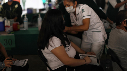 Una mujer embarazada recibe la primera dosis de la vacuna de Pfizer contra la covid-19, en una escuela en Ciudad de México (México).