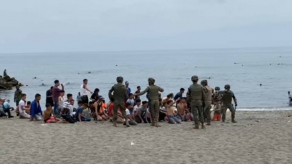 Menores llegados a Ceuta son agrupados en la playa del Tarajal.