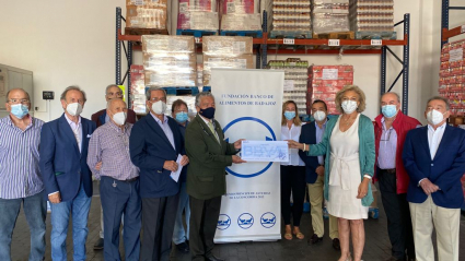 La presidenta del Banco de Alimentos de Badajoz, Cristina Herrera, recibe el cheque del presidente de la Comisión Ciudadana, Pedro Rubio.  