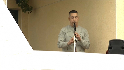 Extremeño tocando el clarinete desde su balcón durante el confinamiento. 