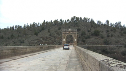 Coches circulando por el puente romano de Alcántara