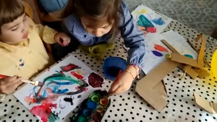 Niños colorean dibujos en su casa