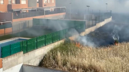 Una dotación de bomberos sofocando el incendio de pastos