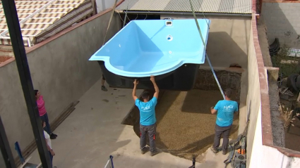 Trabajadores instalan una piscina prefabricada