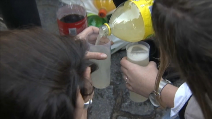 Varios jóvenes echan alcohol en vasos durante un botellón
