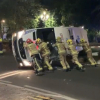 Bomberos empujando una ambulancia volcada tras un accidente