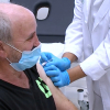 Un médico administra la vacuna de la gripe a un paciente extremeño