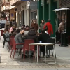 Una de las calles de Cáceres con bares y clientes en sus terrazas