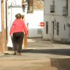 Mujer con bolsa de la compra por la calle de un pueblo